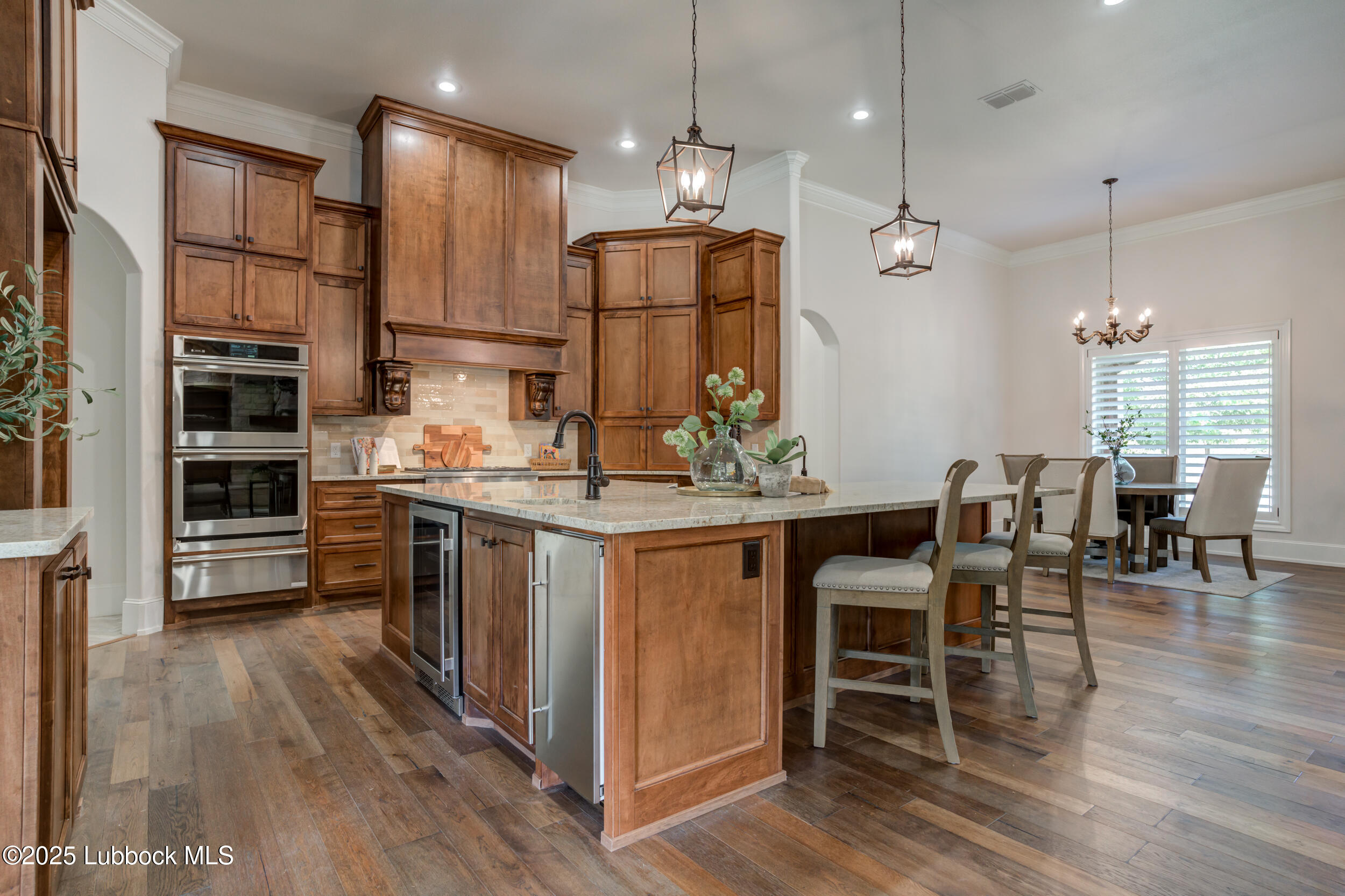 3913 106th Street Lubbock, TX 79423 - Photo 18 of 80 a kitchen with kitchen island granite countertop a stove a sink a dining table and chairs with wooden floor