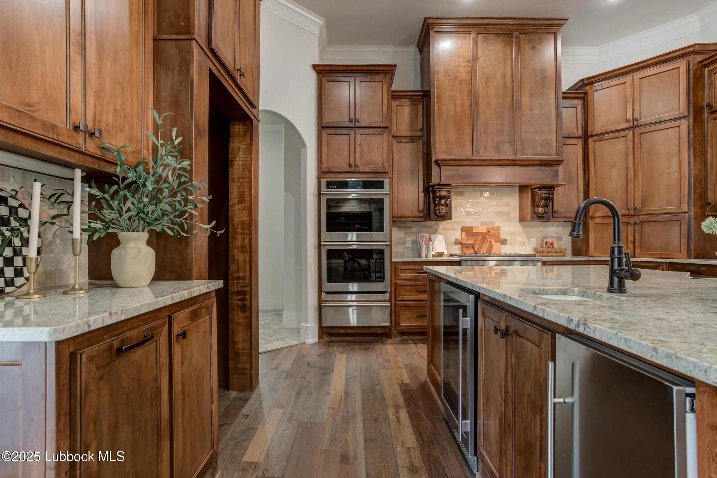 3913 106th Street Lubbock, TX 79423 - Photo 26 of 80 a kitchen with stainless steel appliances granite countertop a refrigerator a stove and a sink with wooden floor