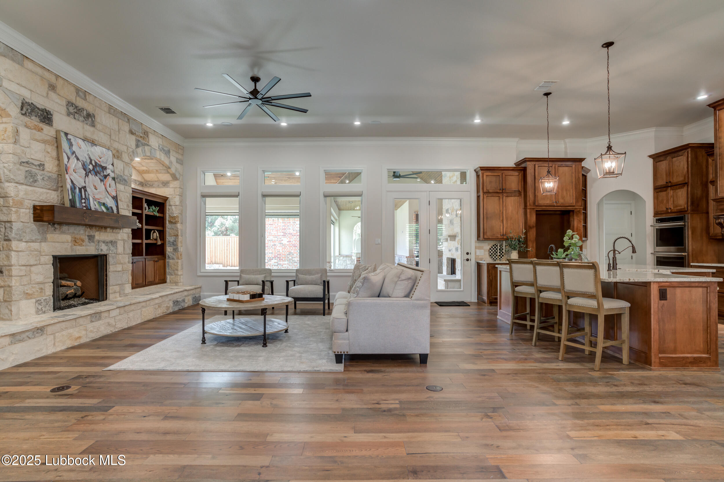 3913 106th Street Lubbock, TX 79423 - Photo 33 of 80 a living room with furniture a fireplace and a dining table with wooden floor