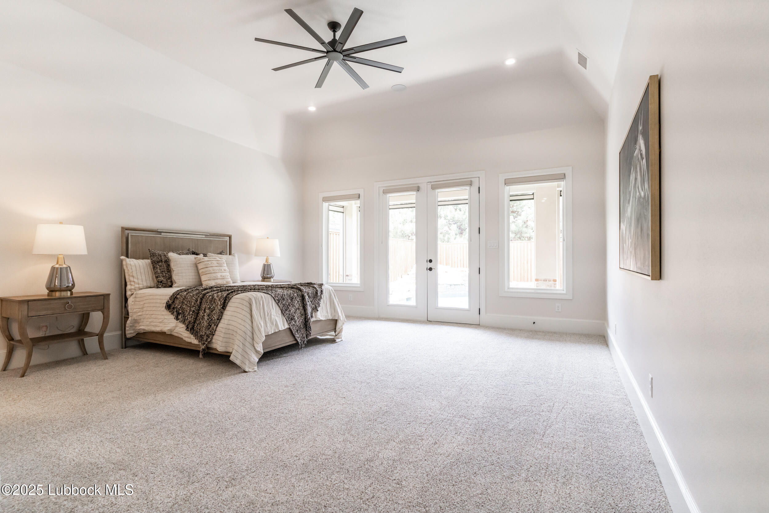 3913 106th Street Lubbock, TX 79423 - Photo 45 of 80 a spacious bedroom with a bed a couch and a chandelier