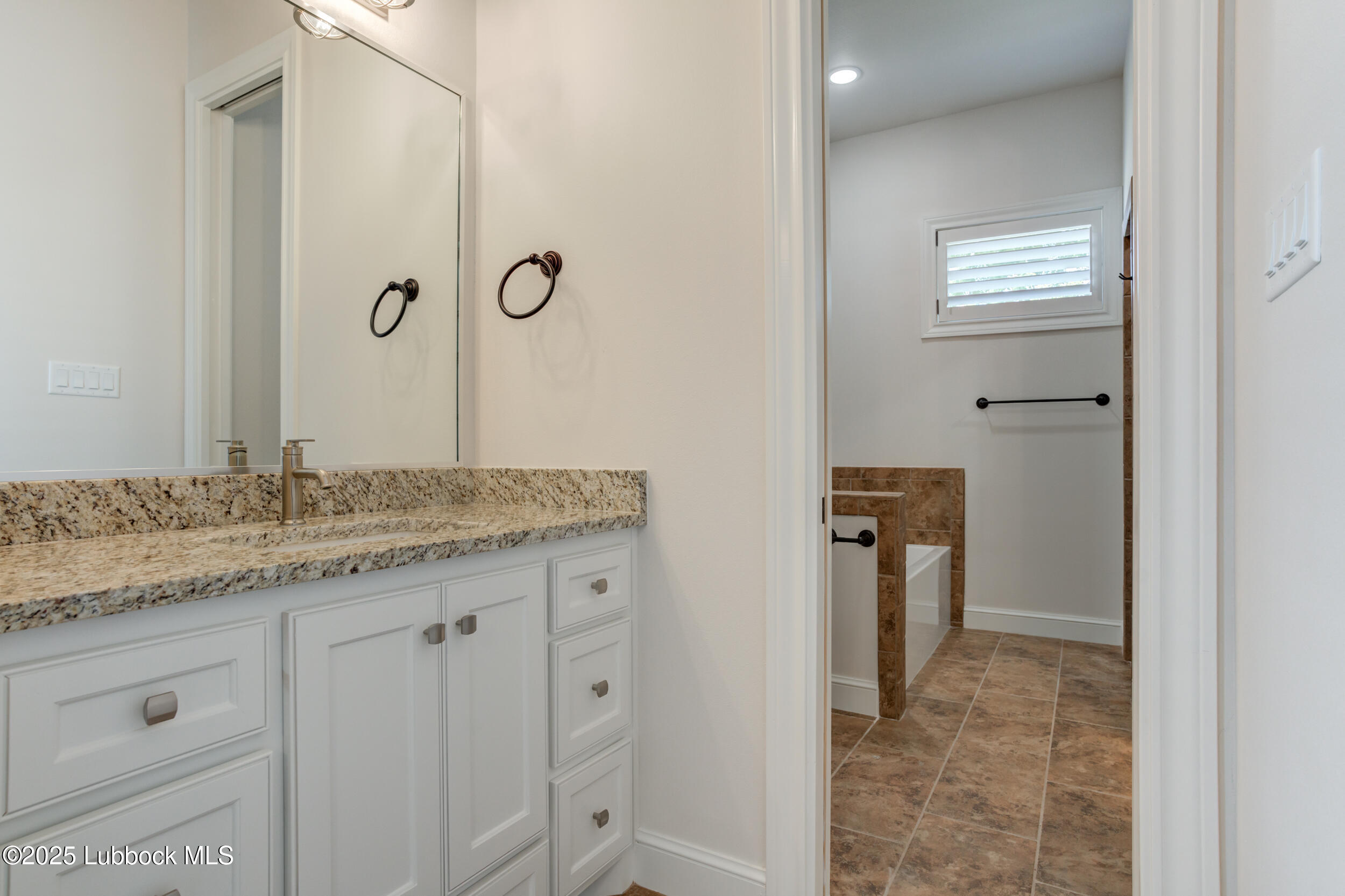 3913 106th Street Lubbock, TX 79423 - Photo 68 of 80 a bathroom with a granite countertop sink and a mirror
