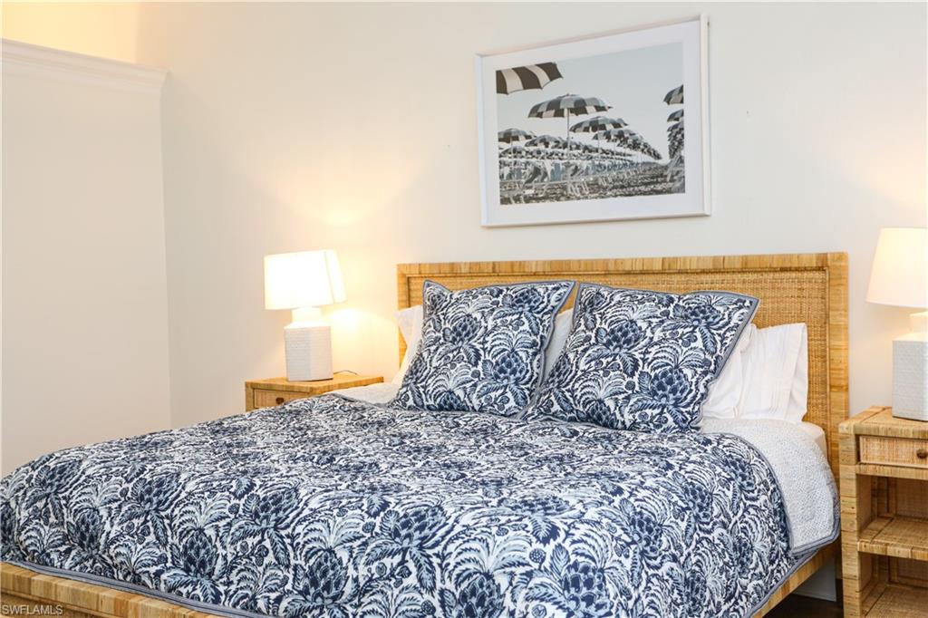1136 6th Street South, Unit 5 Naples, FL 34102 - Photo 16 of 50 a large bed sitting in a bedroom next to a small yard