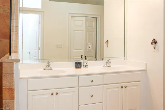 a bathroom with 2 sink and a mirror