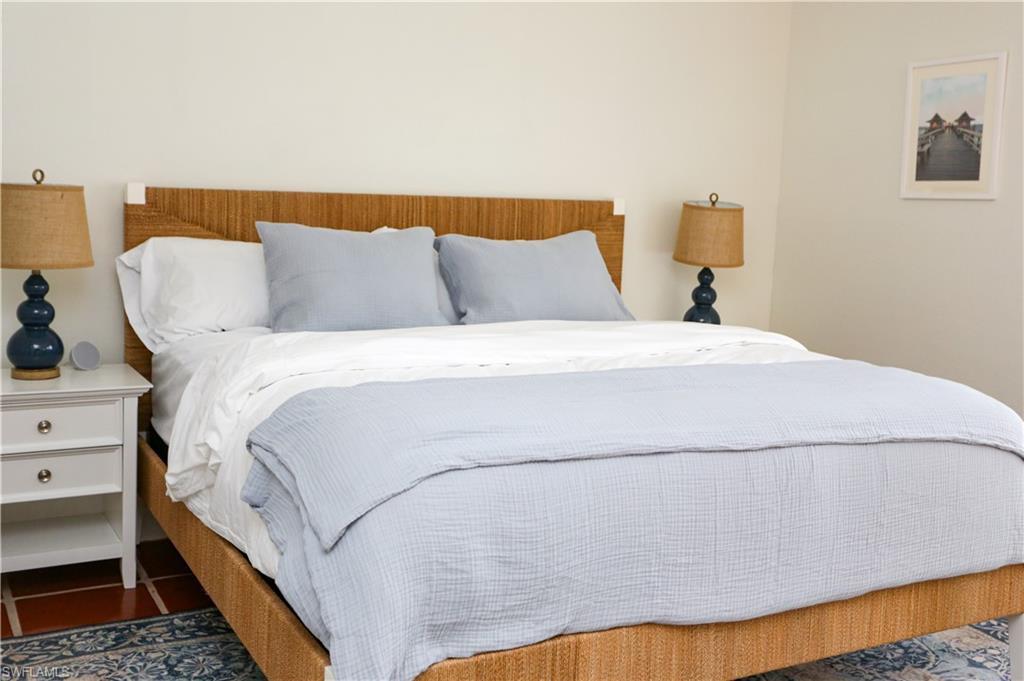 1136 6th Street South, Unit 5 Naples, FL 34102 - Photo 22 of 50 a bedroom with a bed and a night stand