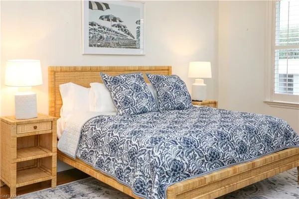 a large bed sitting in a bedroom next to a window