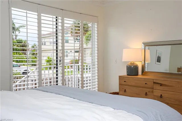 a bedroom with a bed and large windows