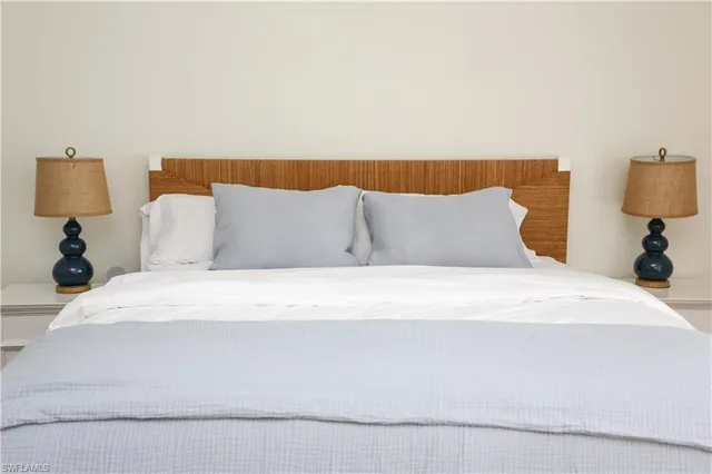 a large bed sitting in a bedroom with a lamp