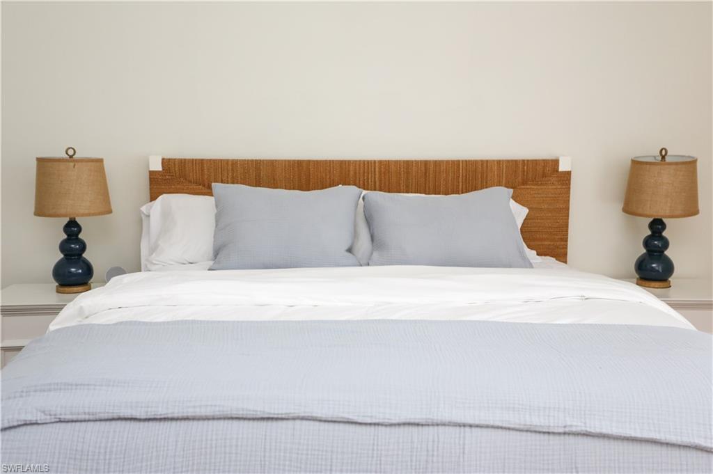 1136 6th Street South, Unit 5 Naples, FL 34102 - Photo 34 of 50 a large bed sitting in a bedroom with a lamp