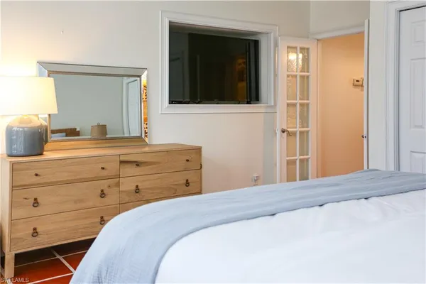 a bedroom with a bed and a mirror on dresser