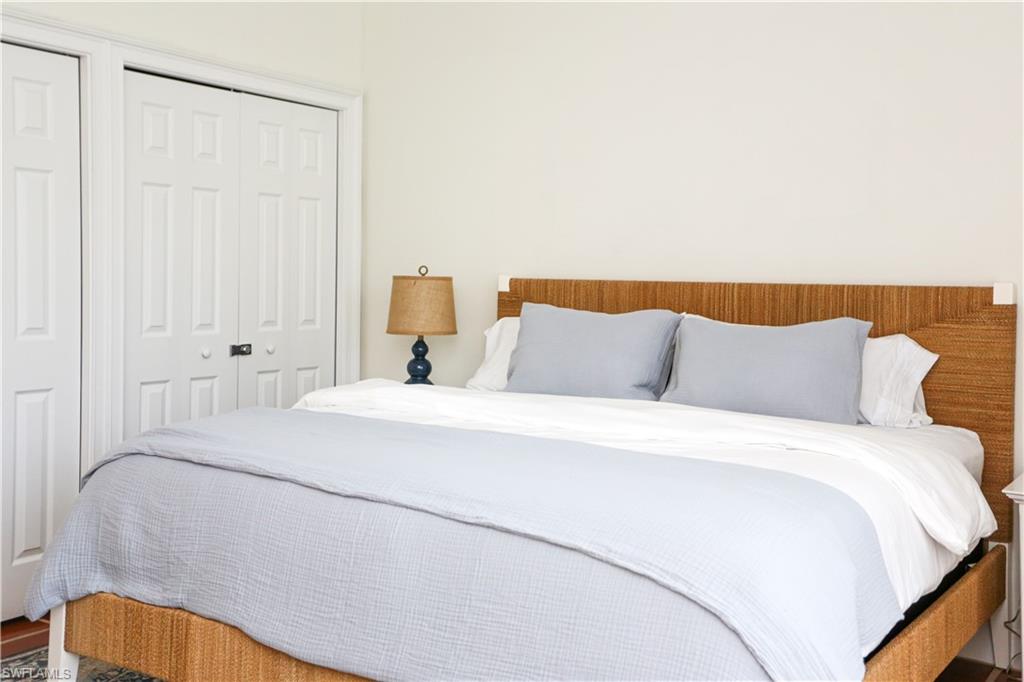 1136 6th Street South, Unit 5 Naples, FL 34102 - Photo 36 of 50 a bedroom with a bed and a lamp