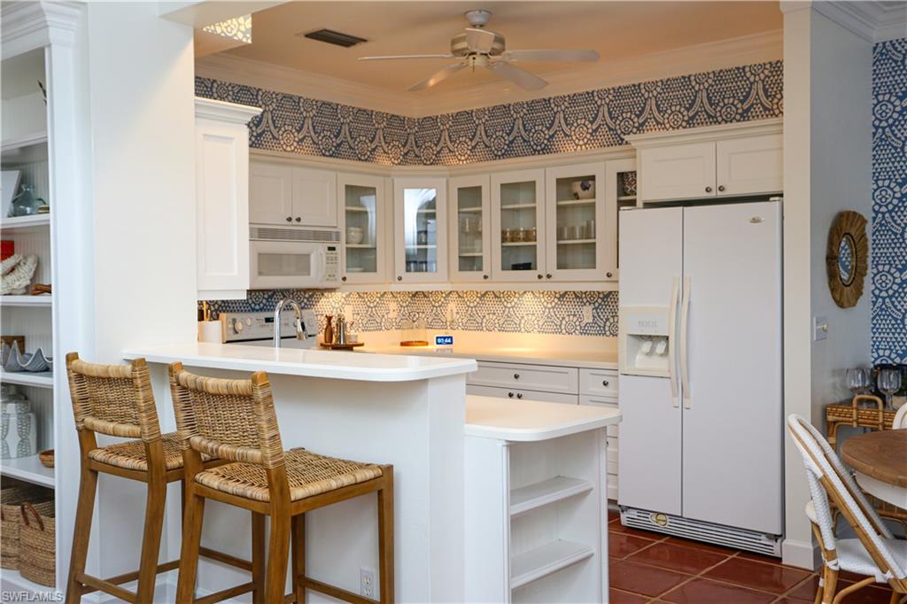 1136 6th Street South, Unit 5 Naples, FL 34102 - Photo 37 of 50 a kitchen with stainless steel appliances granite countertop a sink stove and refrigerator