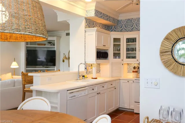 a living room with stainless steel appliances kitchen island granite countertop a sink and a flat screen tv