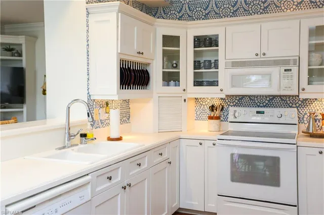 a kitchen with granite countertop white cabinets and white appliances