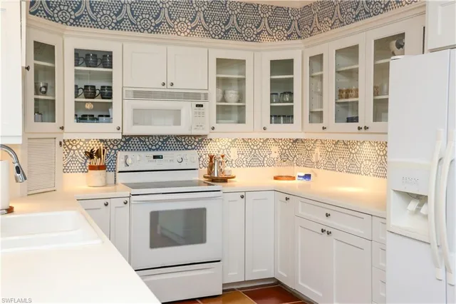 a kitchen with granite countertop white cabinets and white appliances