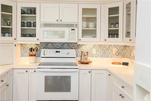 a white kitchen with granite countertop white cabinets and sink