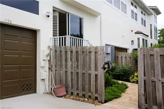 a view of a house with a small yard and wooden floor and fence