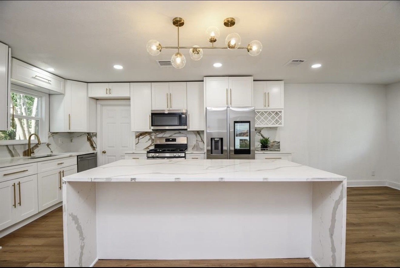 6834 St Augustine Street Houston, TX 77021 - Photo 3 of 21 a large kitchen with kitchen island a sink stainless steel appliances and cabinets