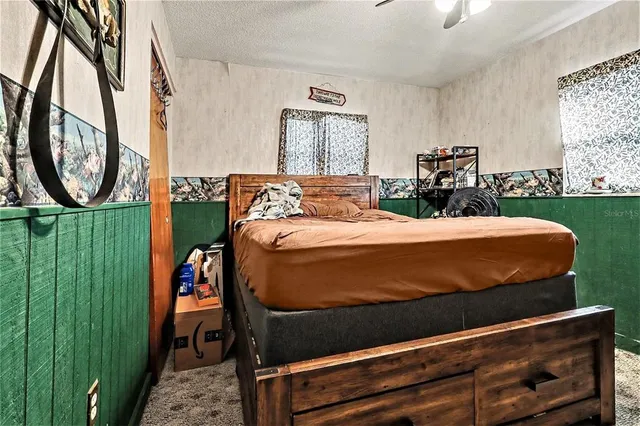 a bedroom with a bed a mirror and dresser with the walls