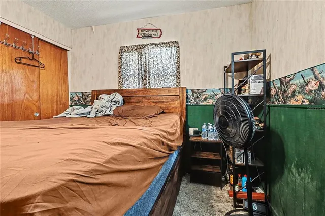 a bedroom with a bed a rug a lamp and a window