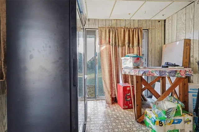 a living room with patio furniture and a floor to ceiling window