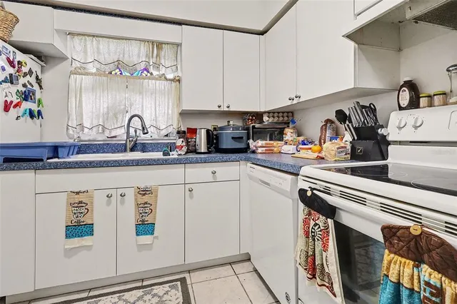 a kitchen with granite countertop white cabinets and white appliances