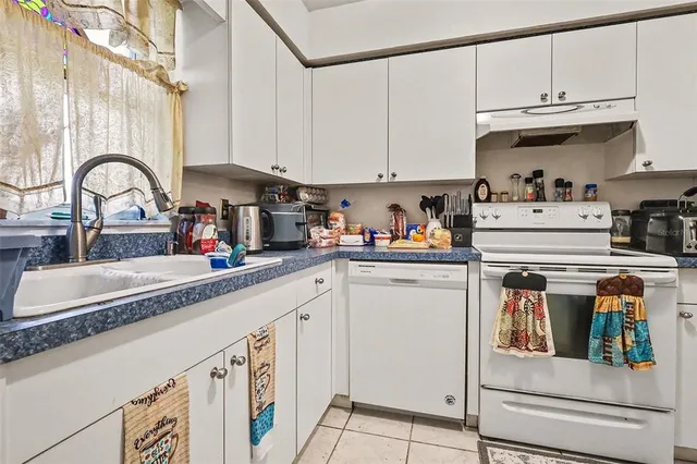 a kitchen with granite countertop lots of clutter and stainless steel appliances