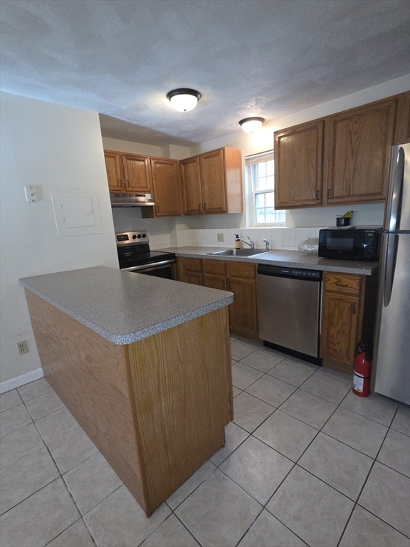 25 Arlington Road, Unit 11 Woburn, MA 01801 - Photo 12 of 14 a kitchen with stainless steel appliances granite countertop a sink counter space cabinets and a window