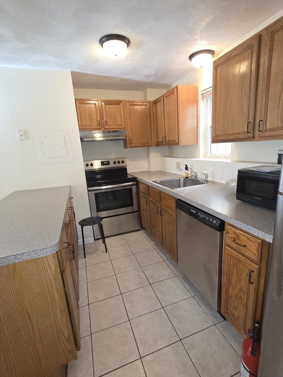 25 Arlington Road, Unit 11 Woburn, MA 01801 - Photo 13 of 14 a kitchen with stainless steel appliances a sink stove and cabinets