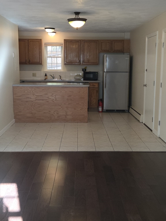 25 Arlington Road, Unit 11 Woburn, MA 01801 - Photo 4 of 14 a kitchen with a sink a microwave and cabinets