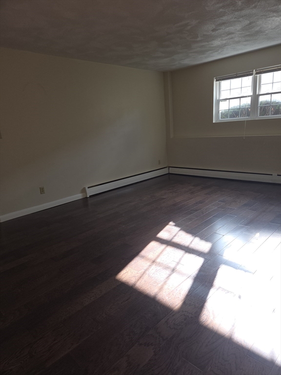 25 Arlington Road, Unit 11 Woburn, MA 01801 - Photo 6 of 14 a view of wooden floor and windows in an empty room