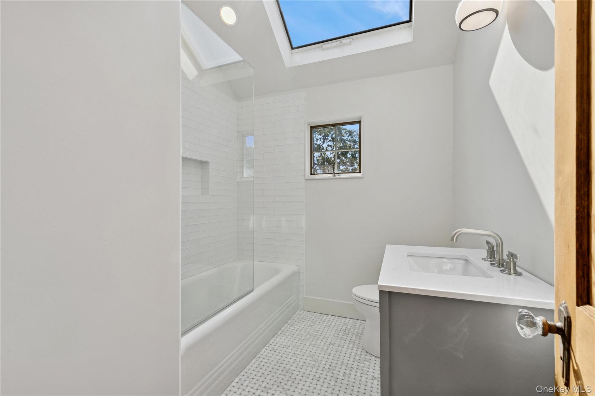 335 Herricks Lane, Unit A Jamesport, NY 11901 - Photo 14 of 18 a bathroom with a sink a mirror and a bathtub