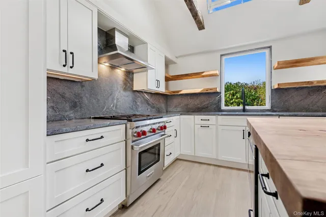 a kitchen with granite countertop white cabinets and white appliances
