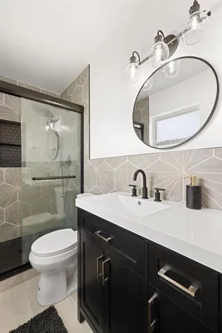 a bathroom with a toilet a sink a mirror and vanity