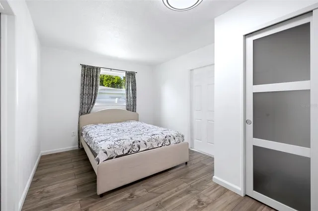 a bedroom with a bed and wooden floor