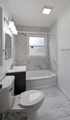 a bathroom with a toilet a sink and bathtub