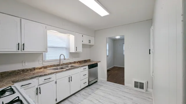 a spacious bathroom with a granite countertop sink and a mirror