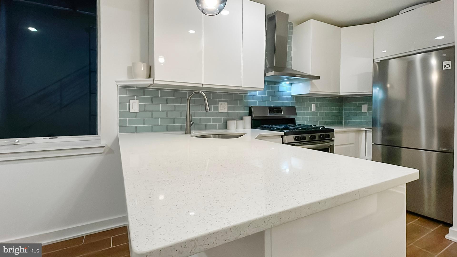 4727 Walnut Street, Unit 4 Philadelphia, PA 19139 - Photo 14 of 26 a kitchen with stainless steel appliances a refrigerator a sink a stove and cabinets