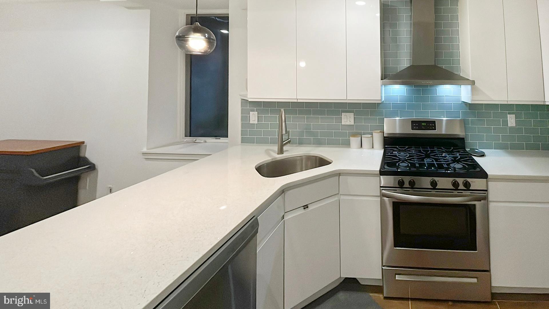 4727 Walnut Street, Unit 4 Philadelphia, PA 19139 - Photo 4 of 26 a kitchen with granite countertop a stove a sink and a microwave