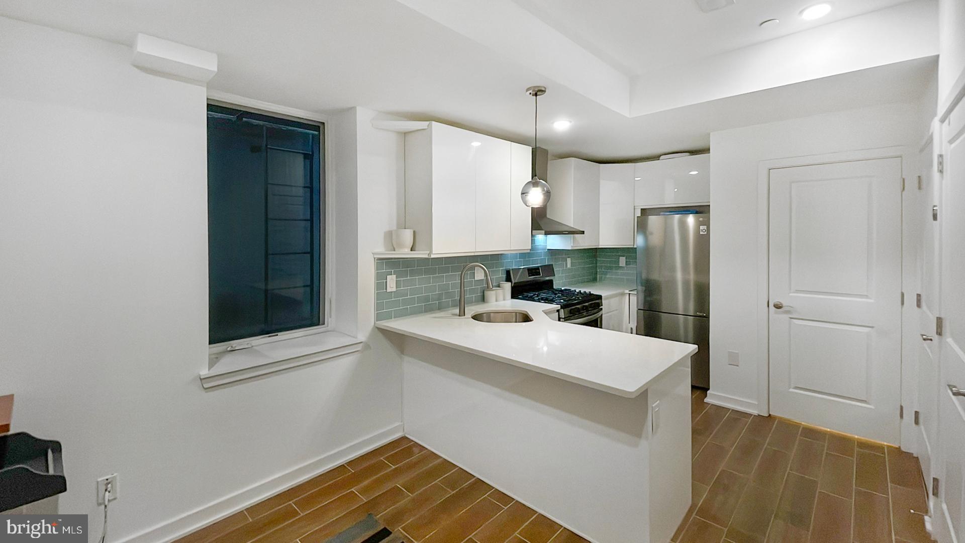 4727 Walnut Street, Unit 4 Philadelphia, PA 19139 - Photo 8 of 26 a kitchen with a sink a refrigerator and cabinets