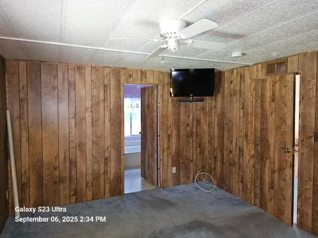 a view of a hallway with a chandelier fan and windows