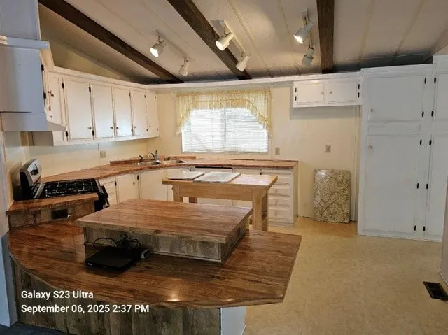 a spacious bedroom with a large bed dresser and a window