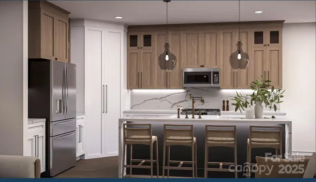 a kitchen with stainless steel appliances kitchen island granite countertop a refrigerator and a stove top oven
