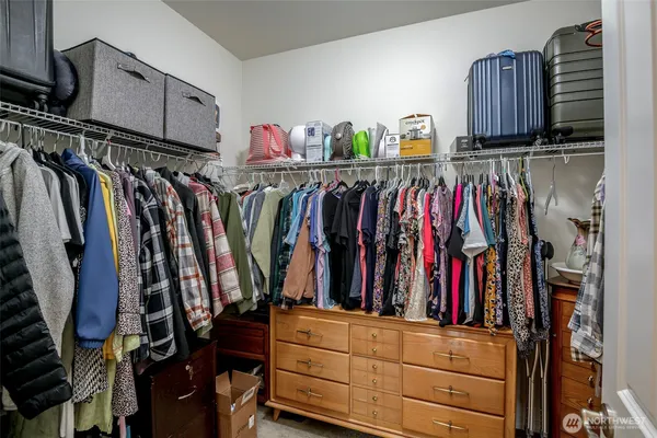 a view of walk in closet with clothes and shoes