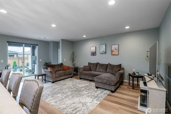 a living room with furniture a flat screen tv and a window