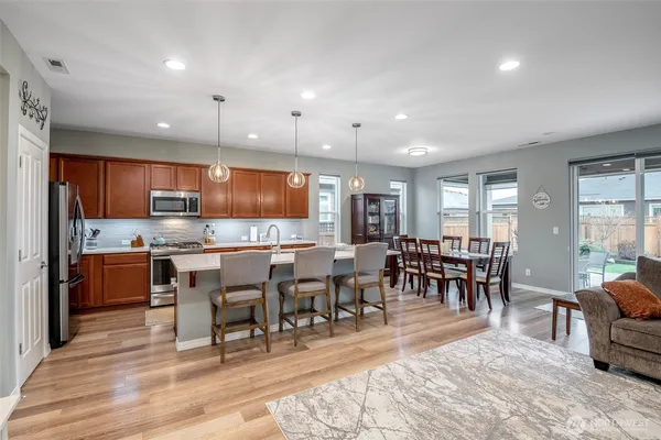 a open kitchen with lots of counter space dining table and stainless steel appliances