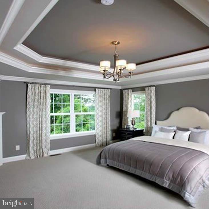 13000 Wainwright Road Highland, MD 20777 - Photo 8 of 11 a bedroom with a large bed and a chandelier