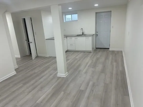 a view of a kitchen with wooden floor and a sink