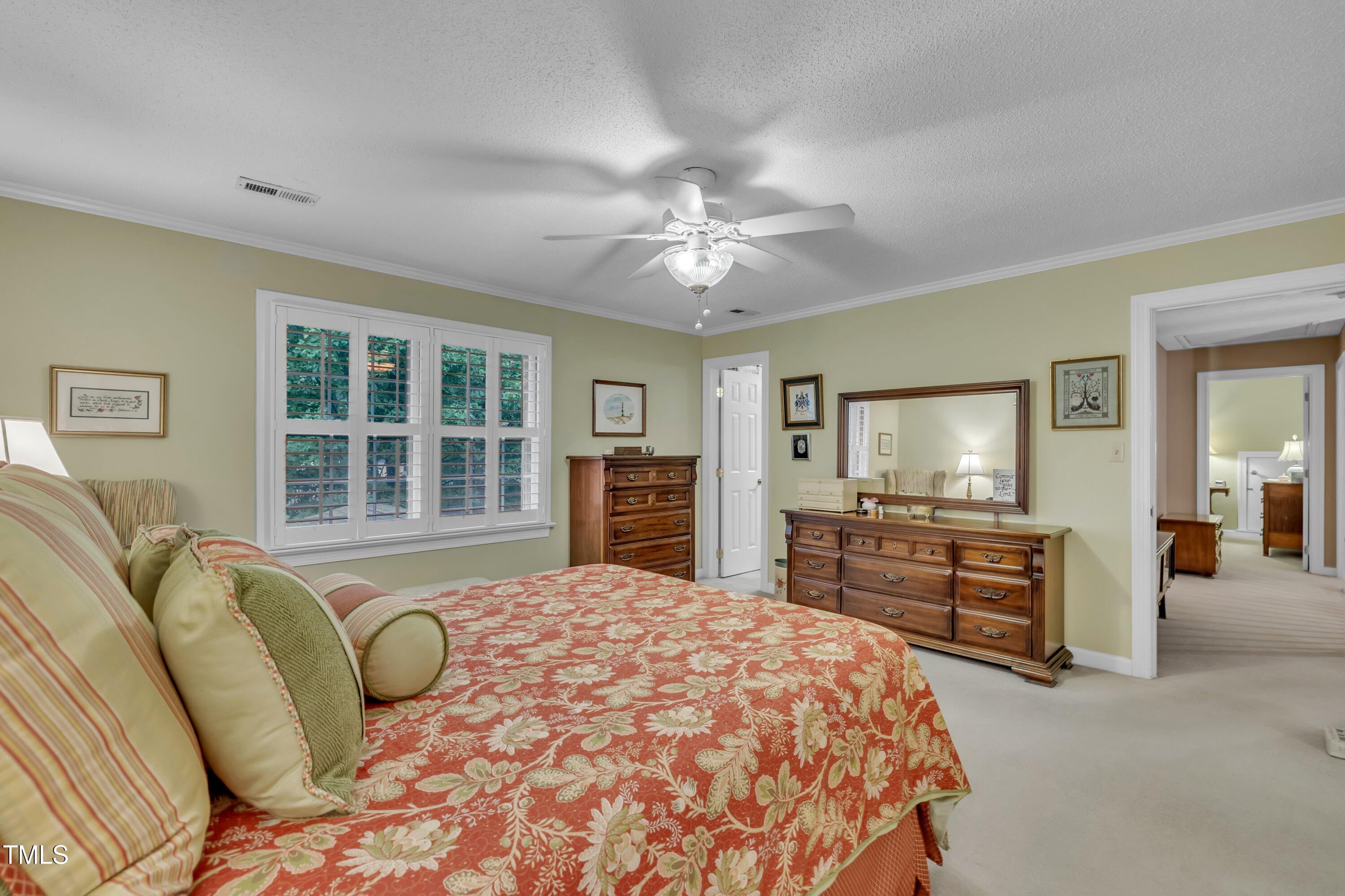 2013 Eagleton Circle Raleigh, NC 27609 - Photo 45 of 62 a spacious bedroom with a bed and dresser with mirror