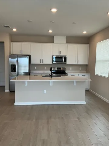 a kitchen with stainless steel appliances white cabinets and a sink