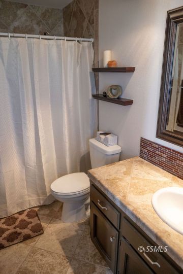 644 Beth Lane Ridgecrest, CA 93555 - Photo 23 of 31 a bathroom with a granite countertop sink and a toilet
